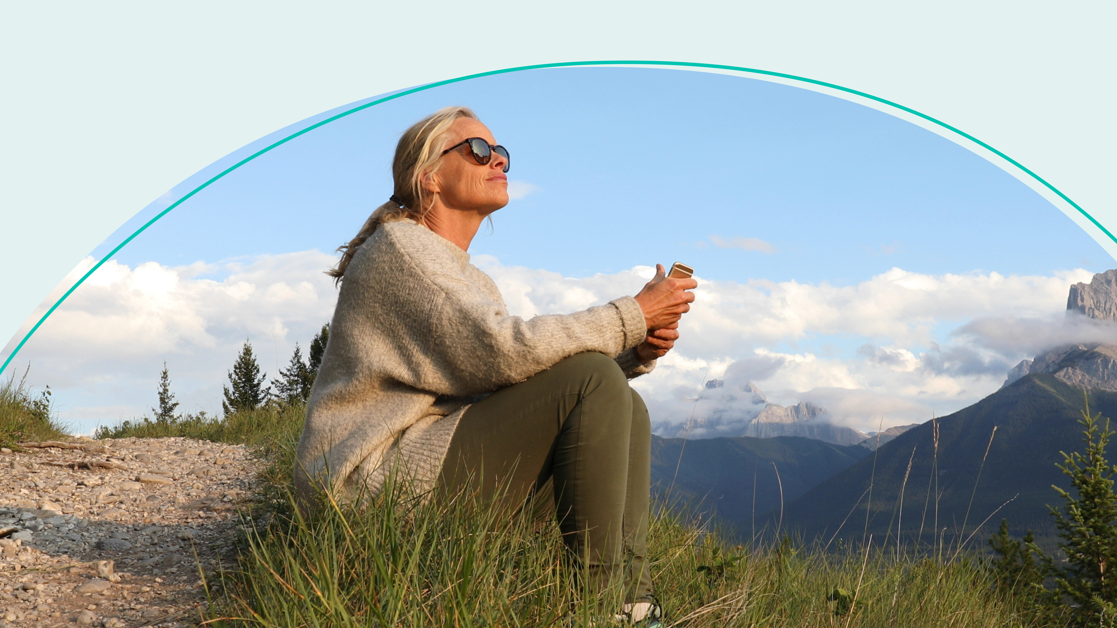 Woman sitting on mountain looking out over landscape