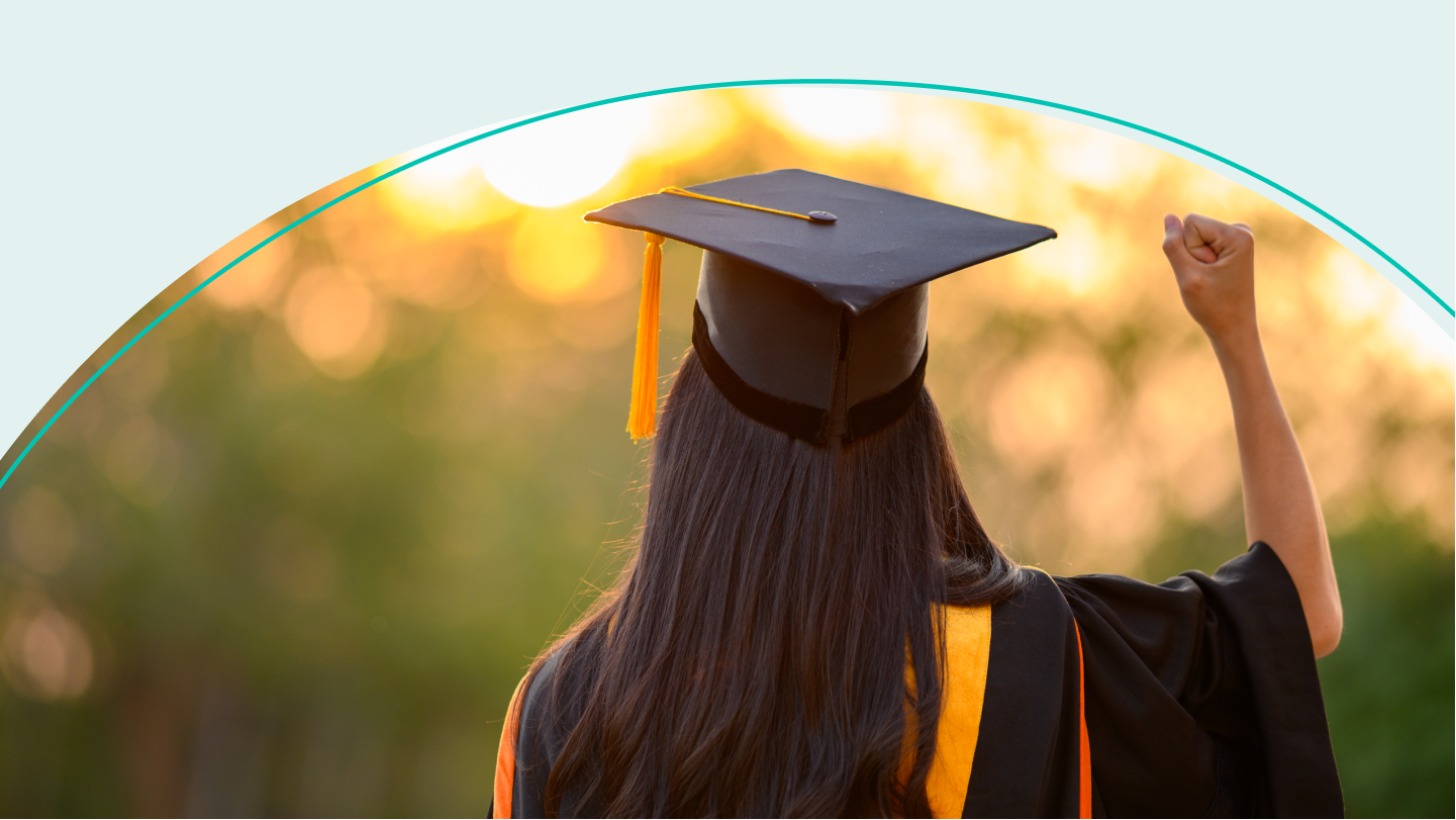 woman in cap and gown raising fist