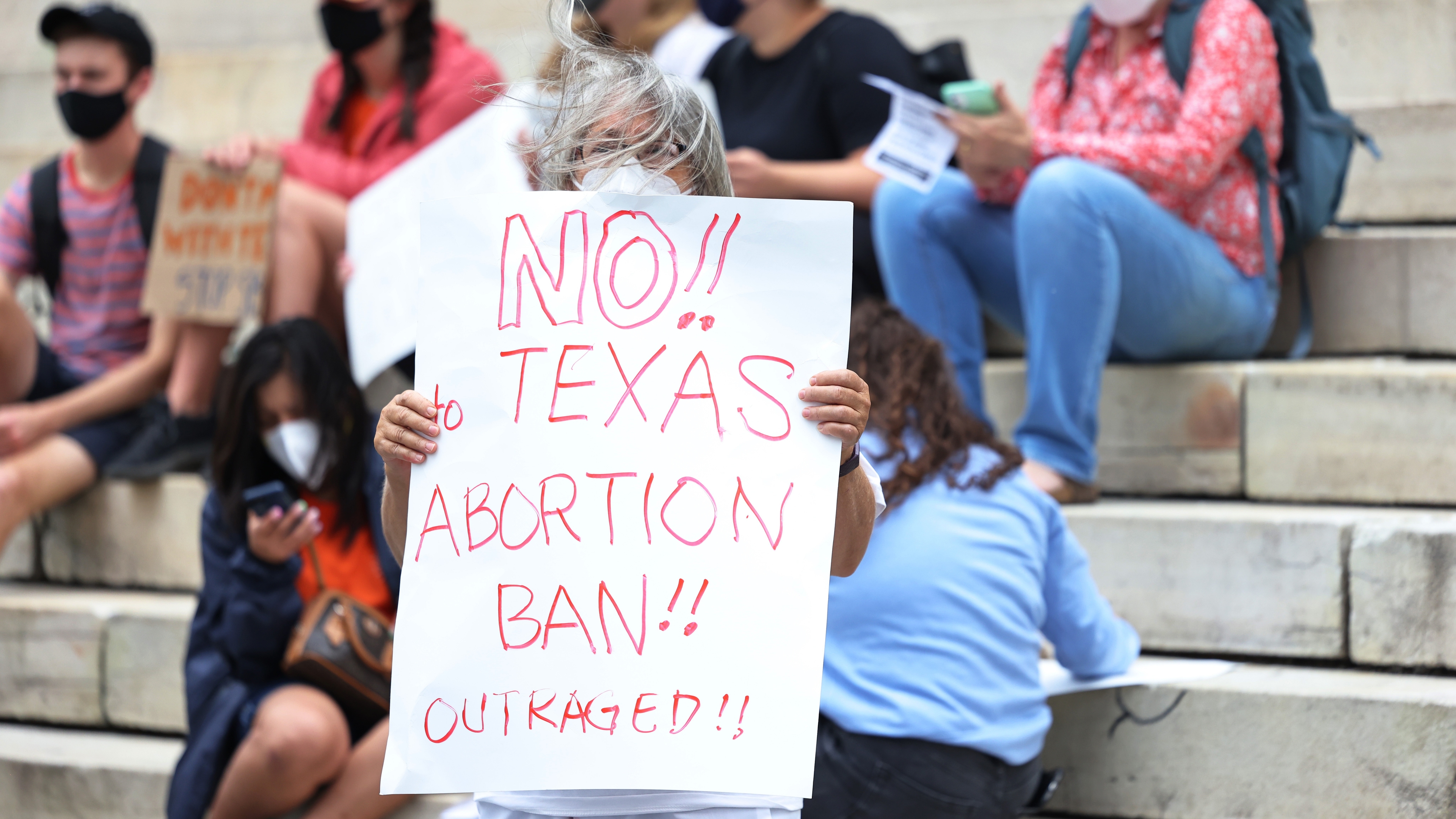 Debra Sweet, holds up a sign as she joins people gathered for a reproductive rights rally