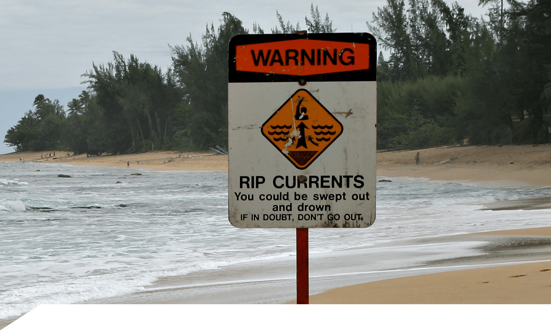 A warning sign for rip currents on a beach