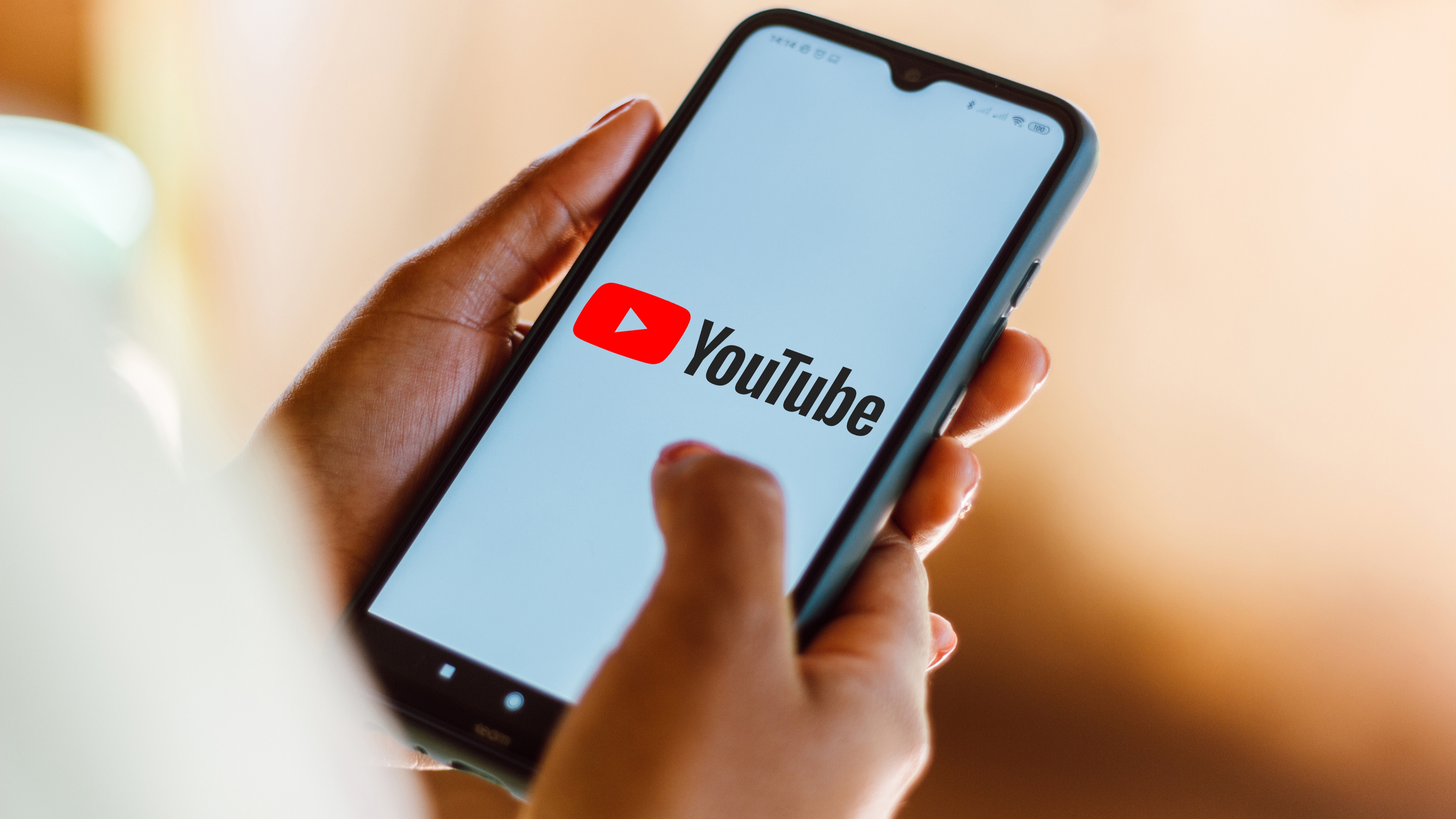 Photo illustration of the YouTube logo seen displayed on a smartphone.