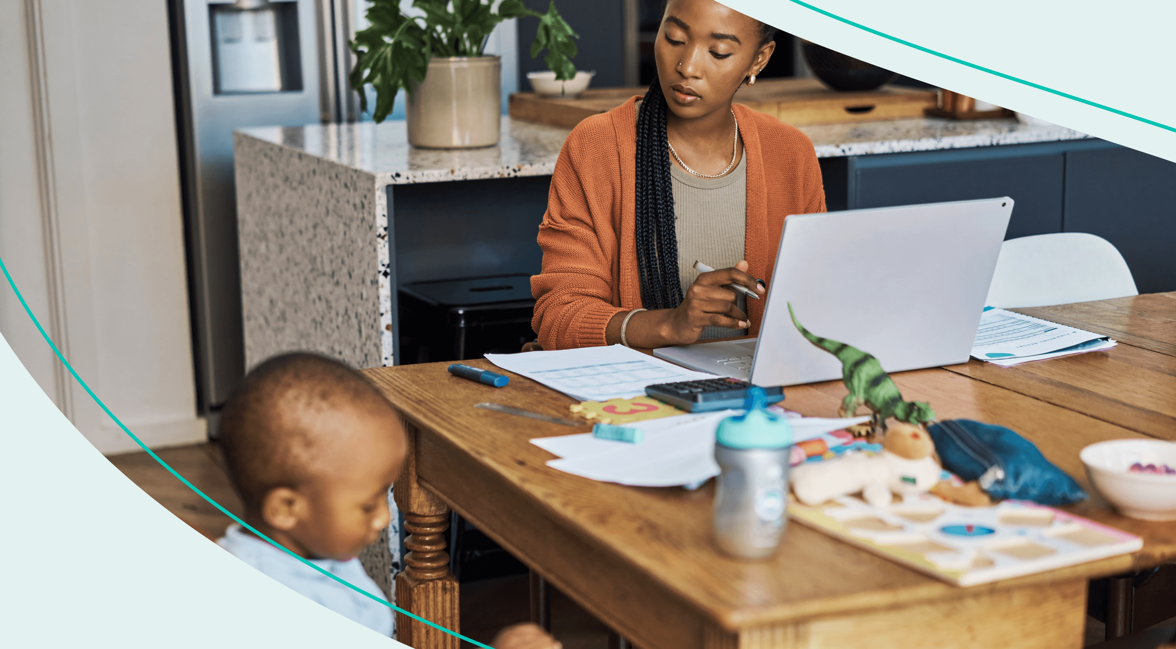 woman doing bills at table while young son plays nearby