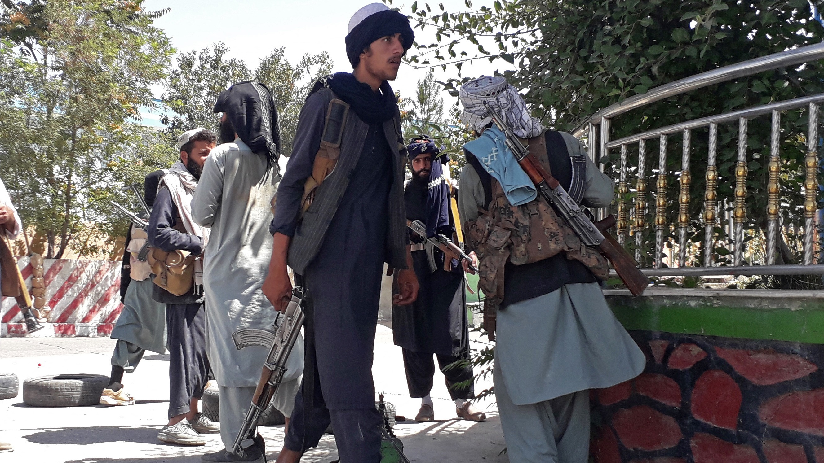 Taliban fighters stand along the roadside in Ghazni