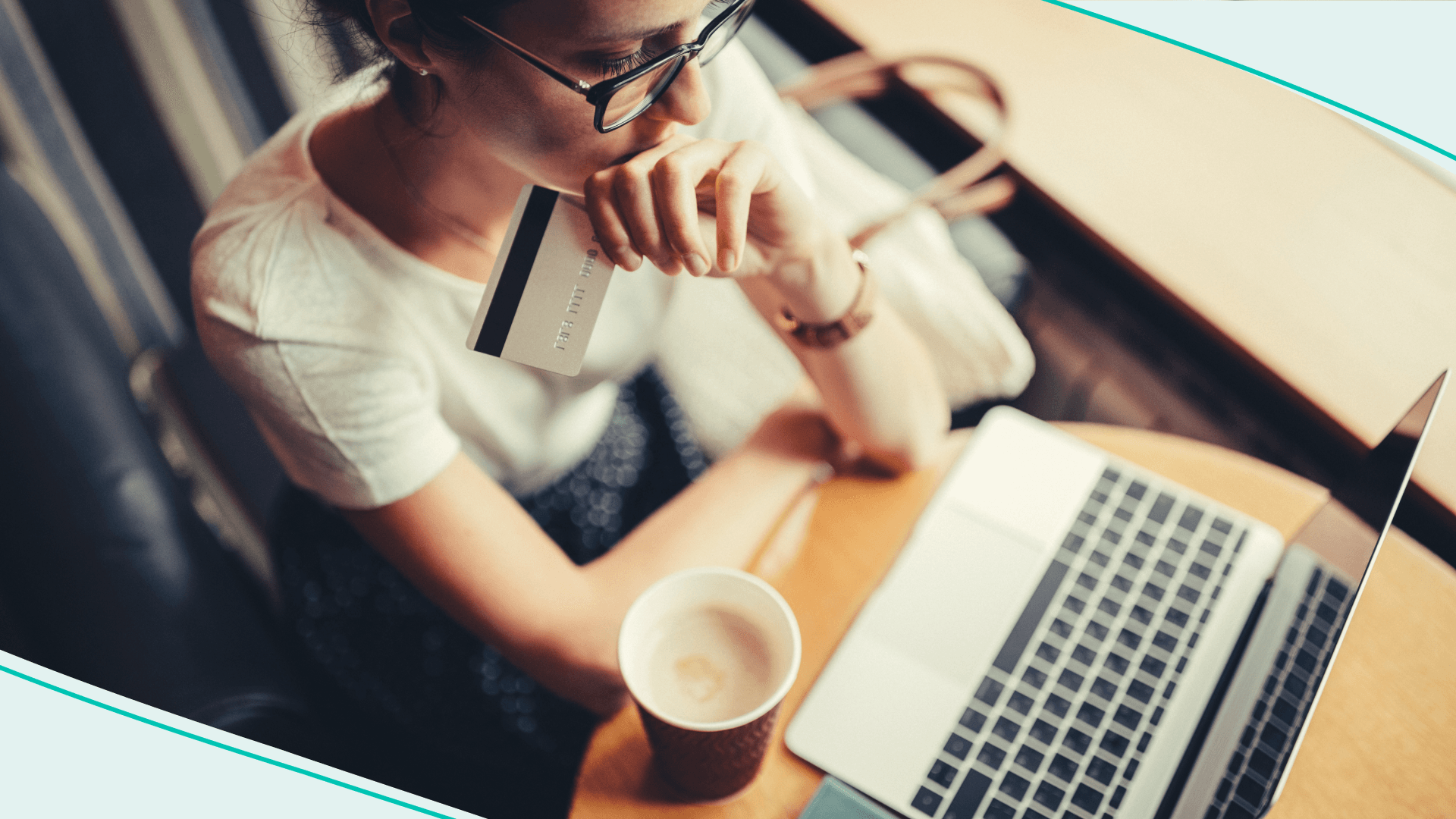 A woman holds a credit card as she online shops