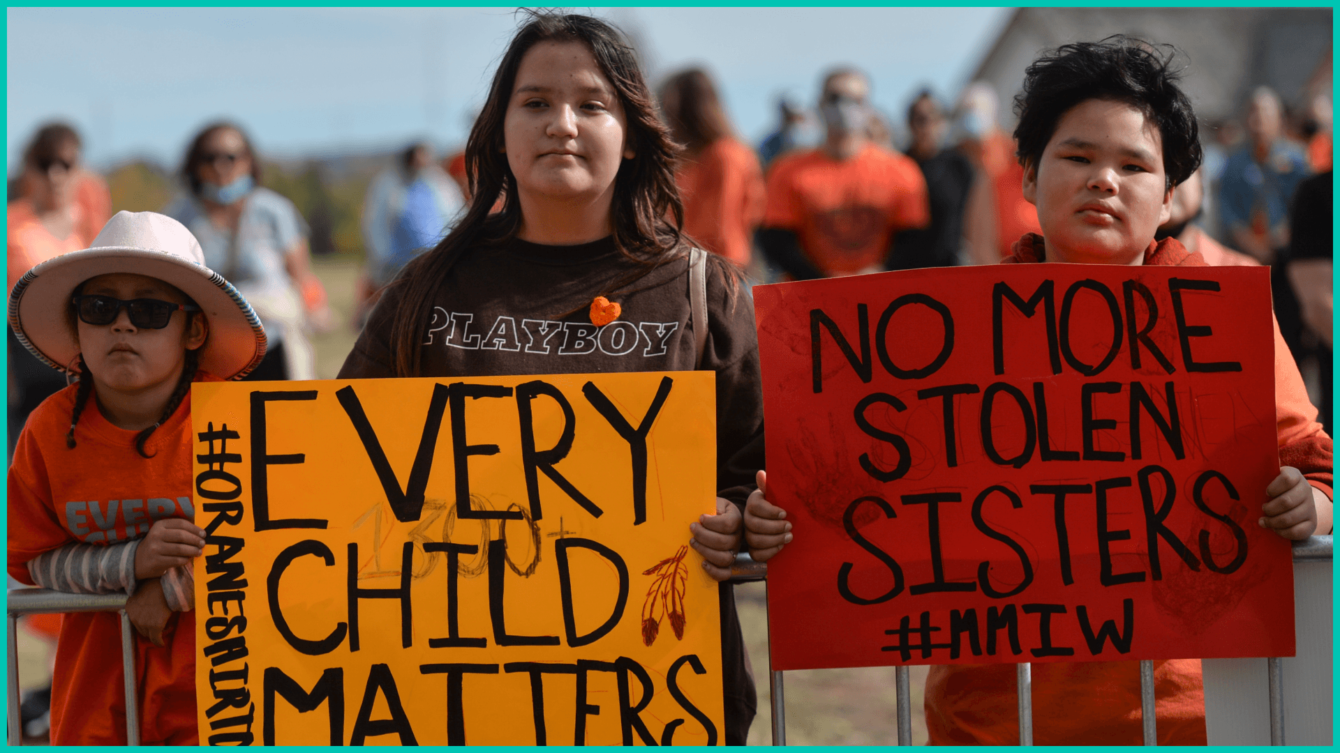 Young members of the First Nations hold placards with words 'Every Child Matter' and 'No More Stolern Sisters'