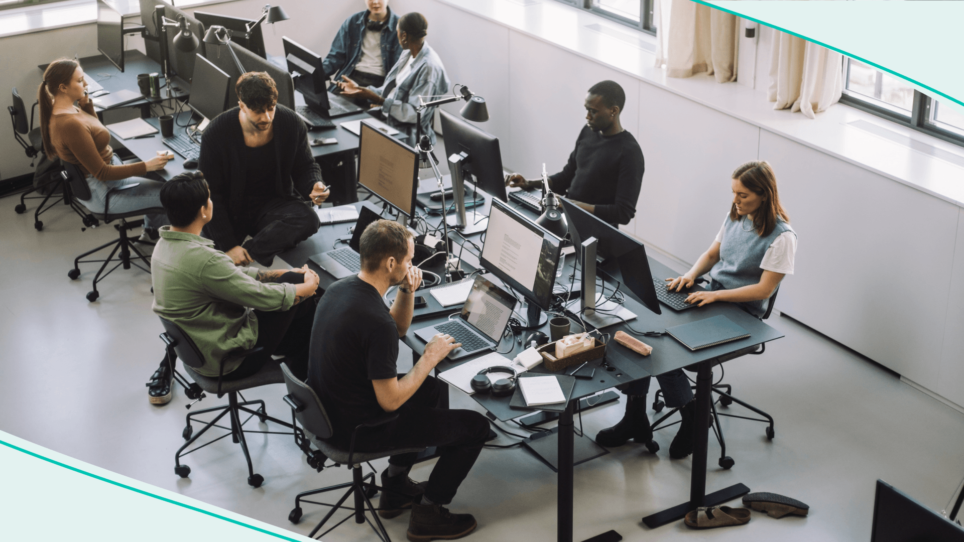 High angle view of male and female programmers working on computers at desk in office