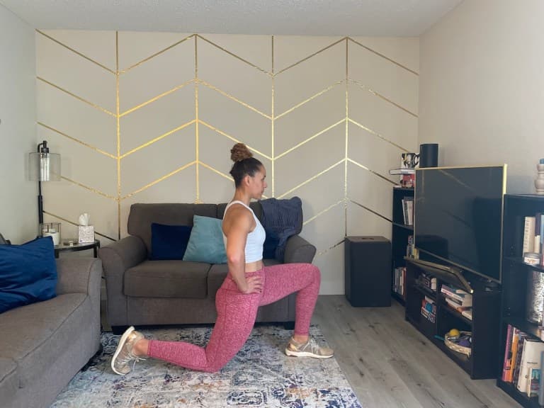 Personal trainer demonstrating half-kneeling hip flexor stretch