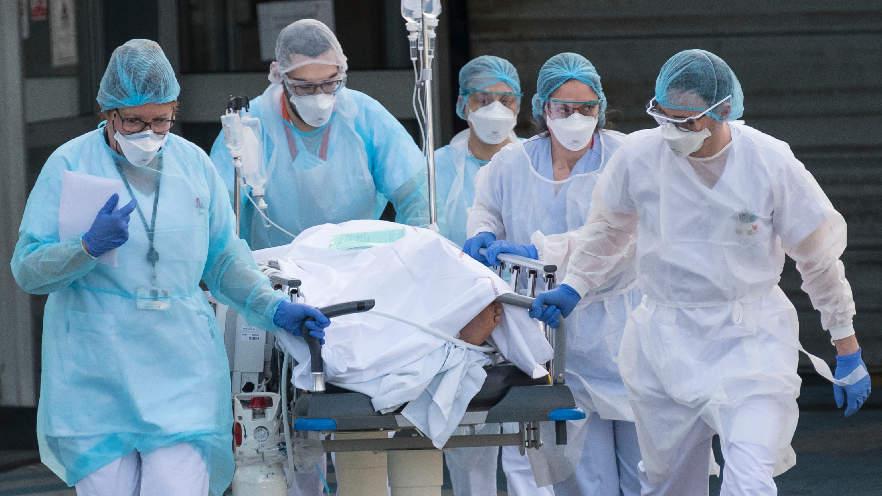 Medical staff push a patient on a gurney to a waiting medical helicopter at the Emile Muller hospital in Mulhouse, eastern France, to be evacuated on another hospital on March 17, 2020.