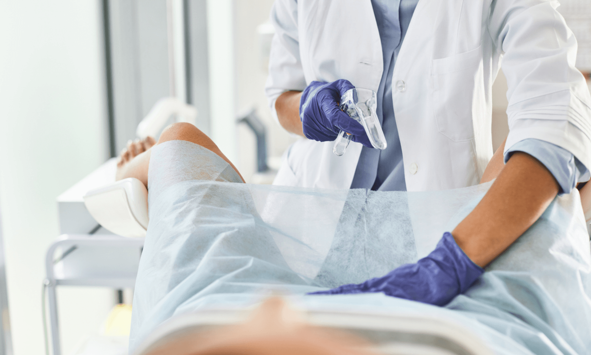 A doctor preparing to perform a pelvic exam with a speculum