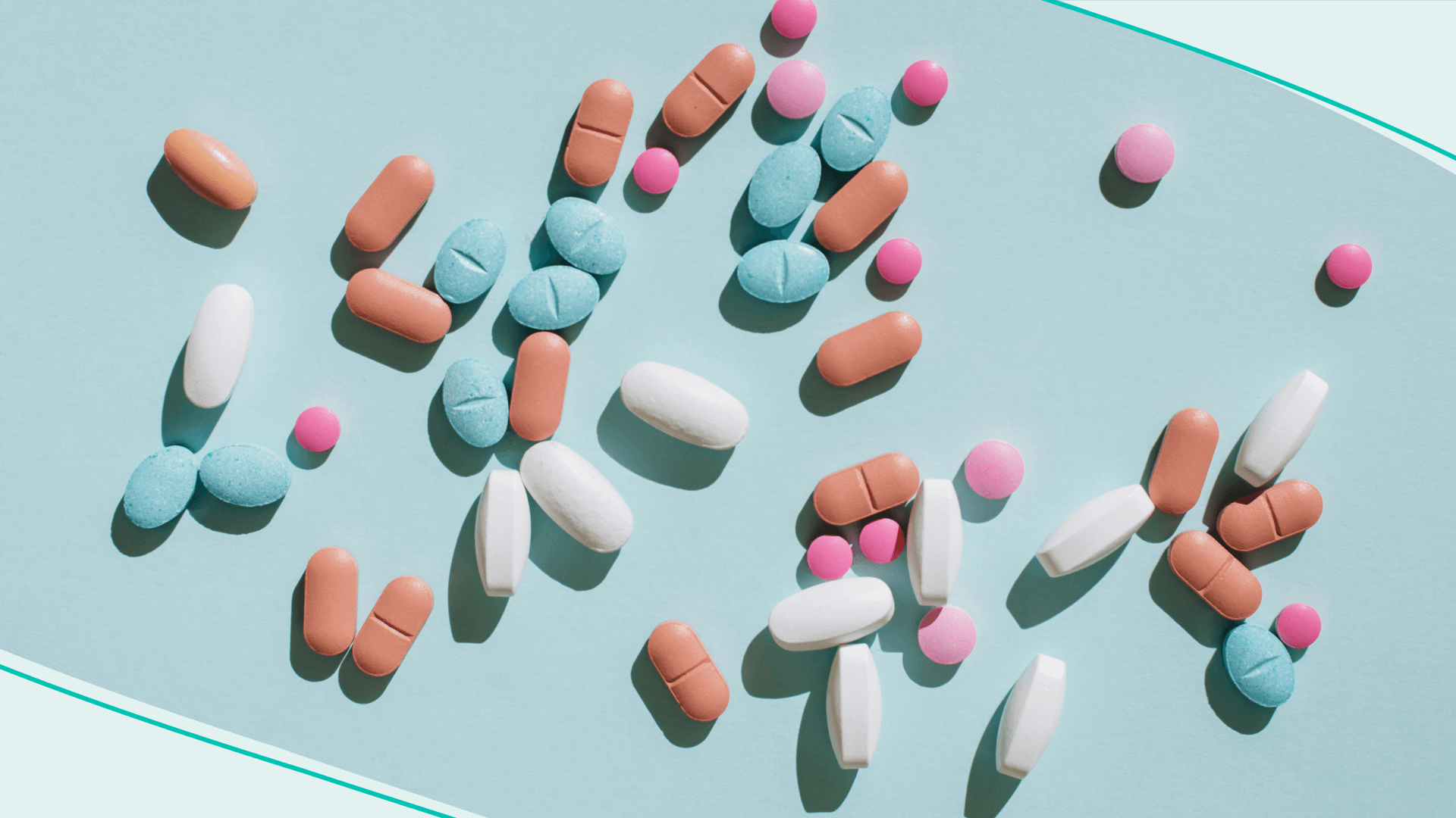 Colorful pills and capsules on blue background. Minimal medical concept. Flat lay, top view.