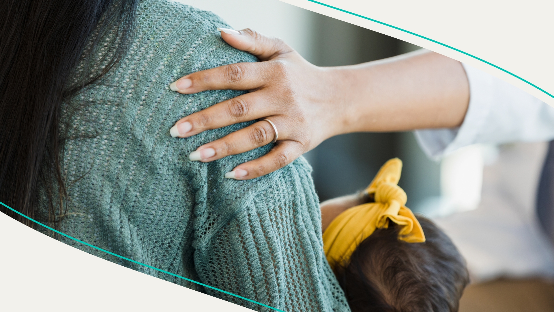 Unrecognizable person places hand on a mother's shoulder as she offers comfort and support.