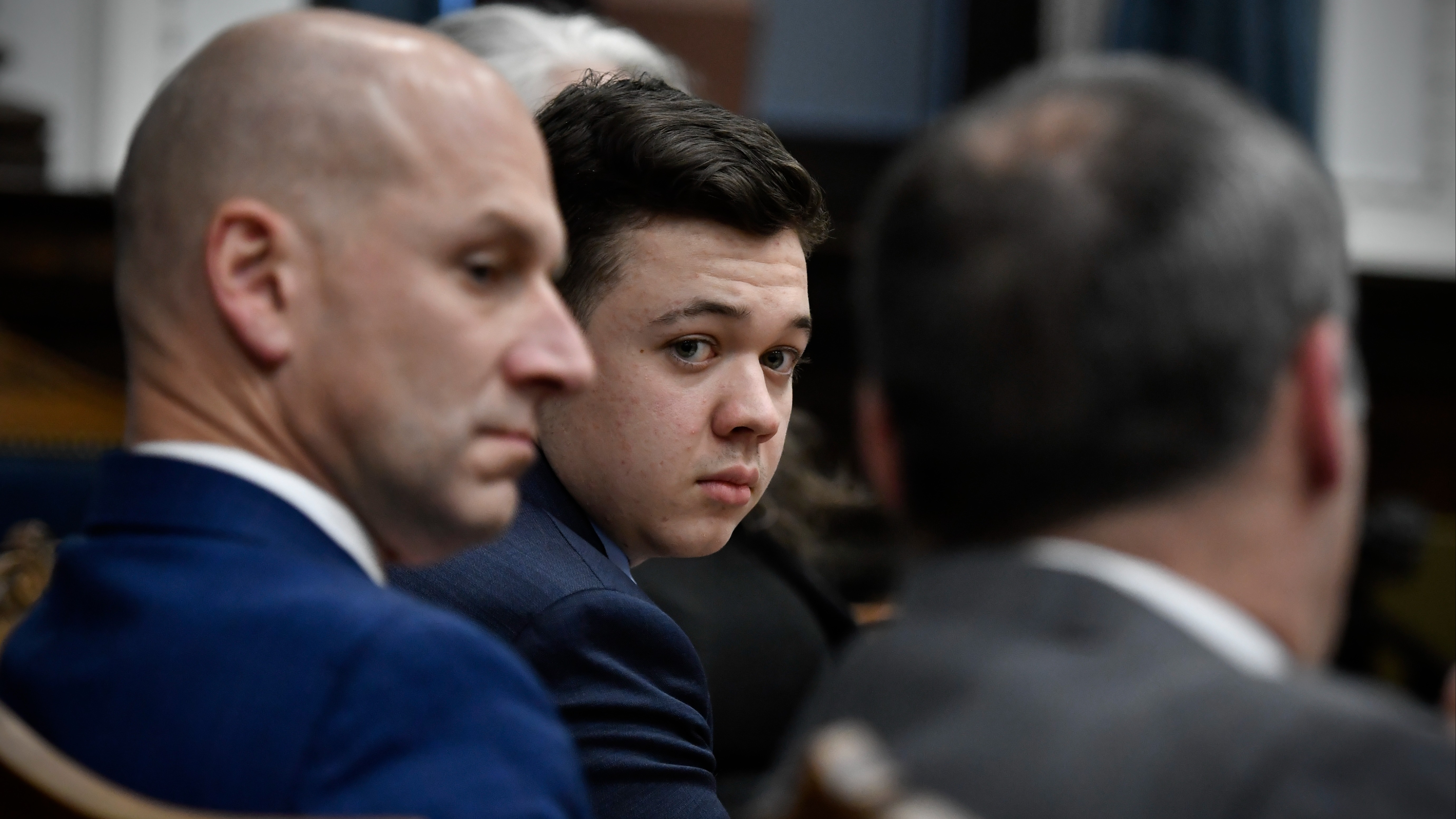 Kyle Rittenhouse, center, looks over to his attorneys as the jury is dismissed for the day during his trial