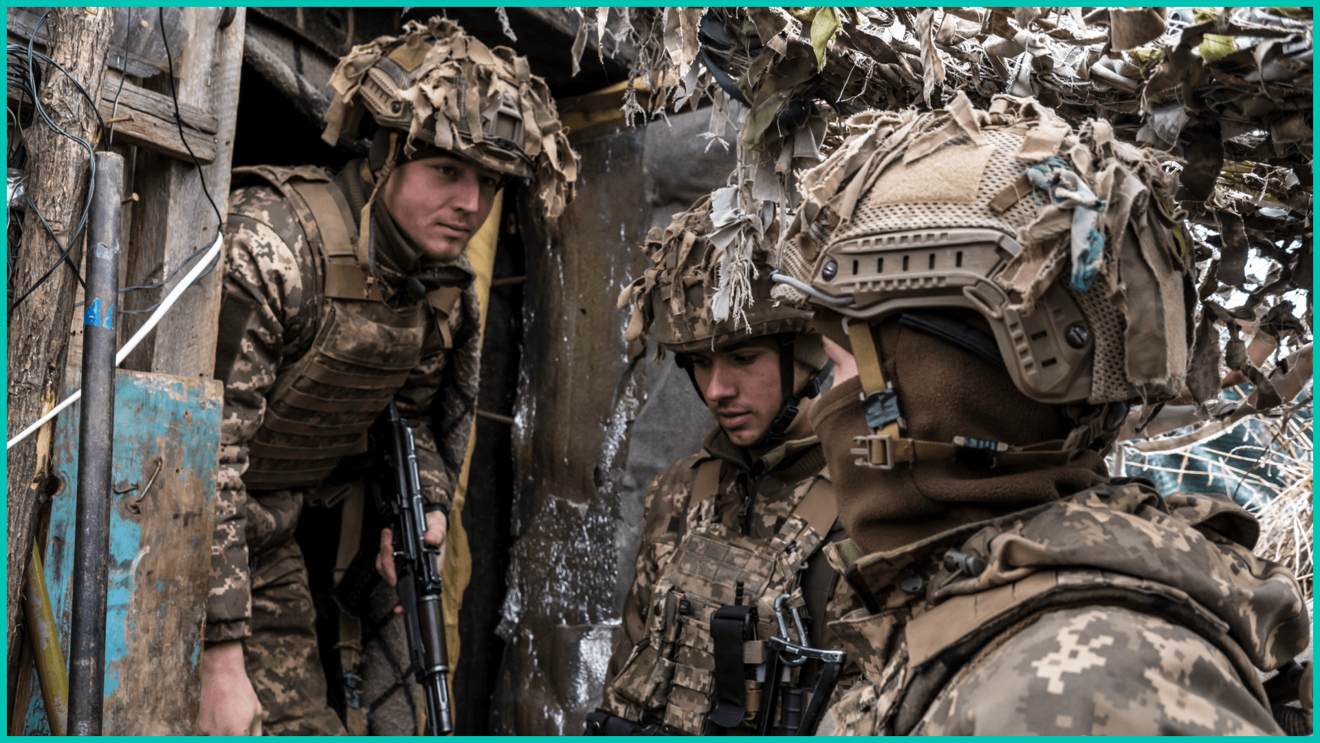 Ukrainian soldiers stand in a trench near the front line