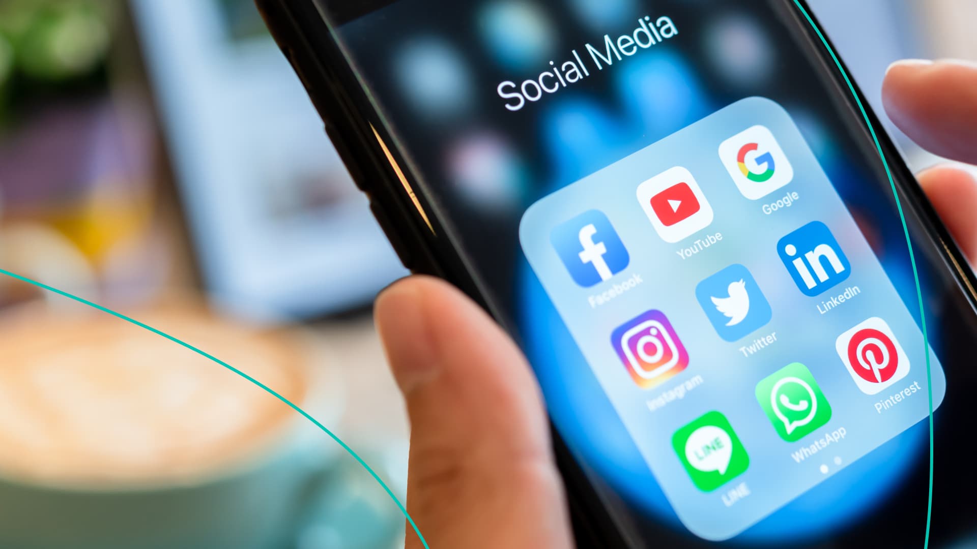 An individual holds a smartphone showing several social media apps