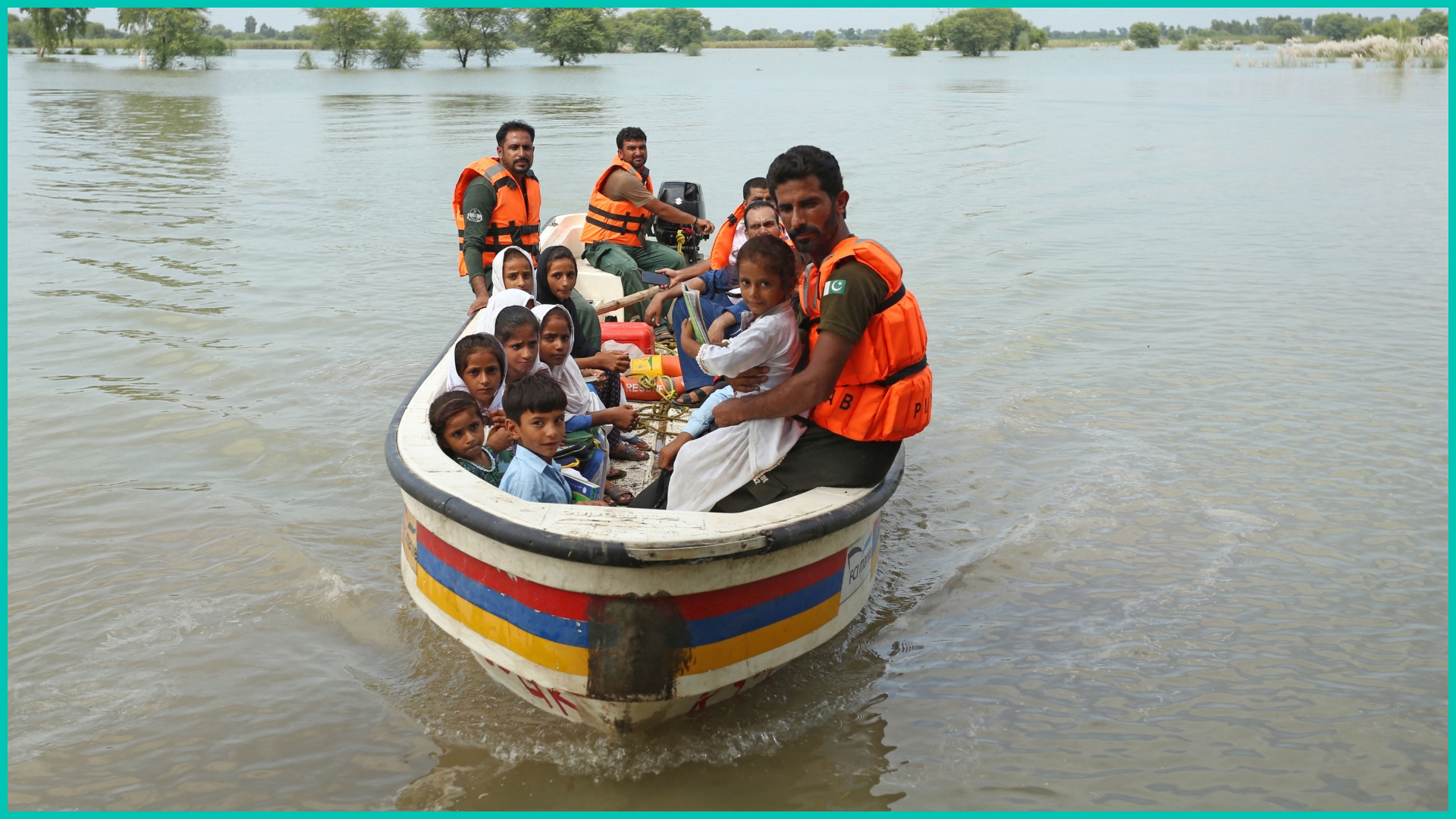 Rescue workers use a boat to drop children back home after school in a flood hit area following heavy monsoon rains in Dera Ghazi Khan district in Punjab province on August 29, 2022.