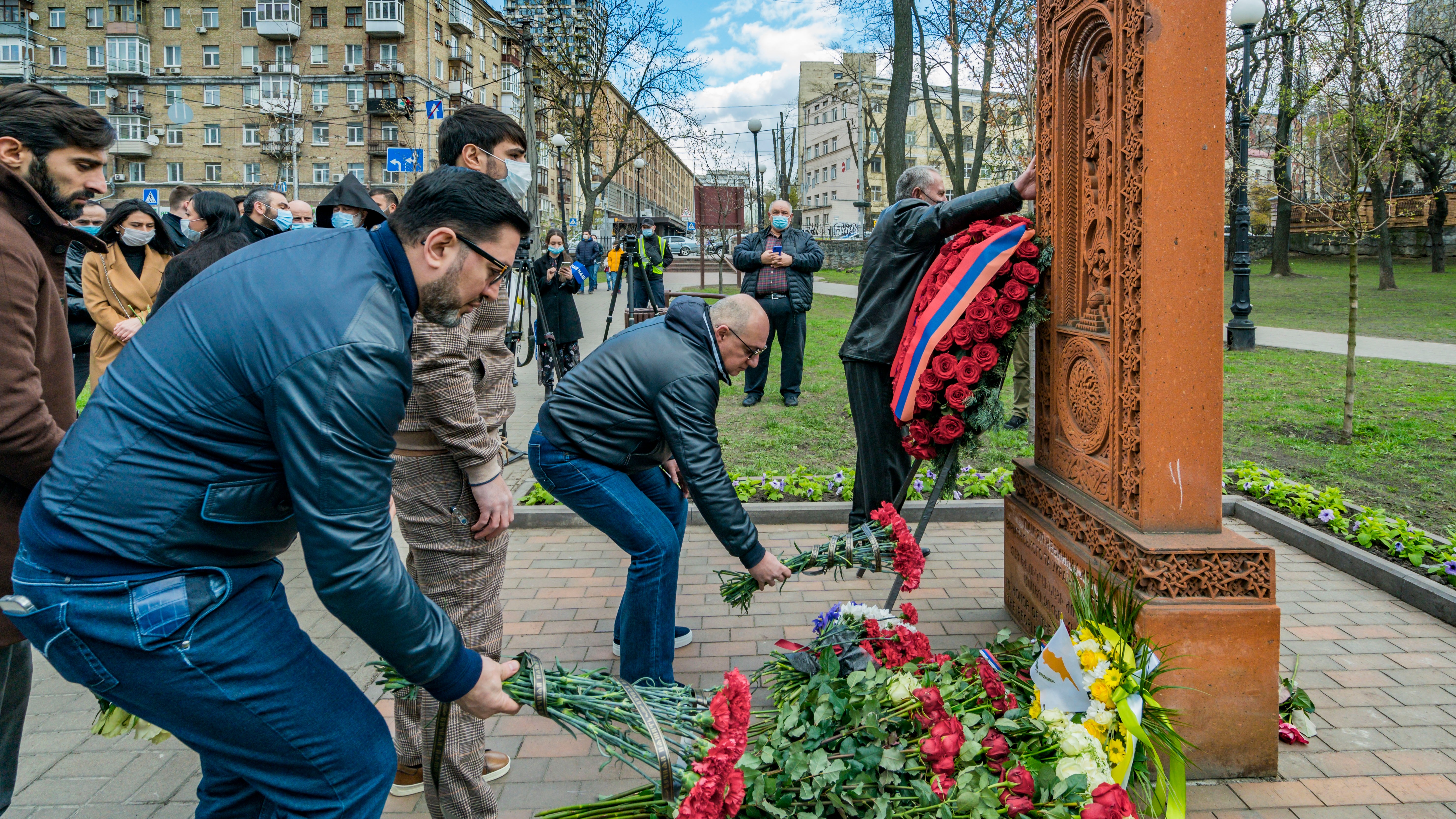 People leave flowers under a khachkar, a memorial stone stele of armenian culture, during the Armenian Genocide Remembrance Day in Kiev, Ukraine.