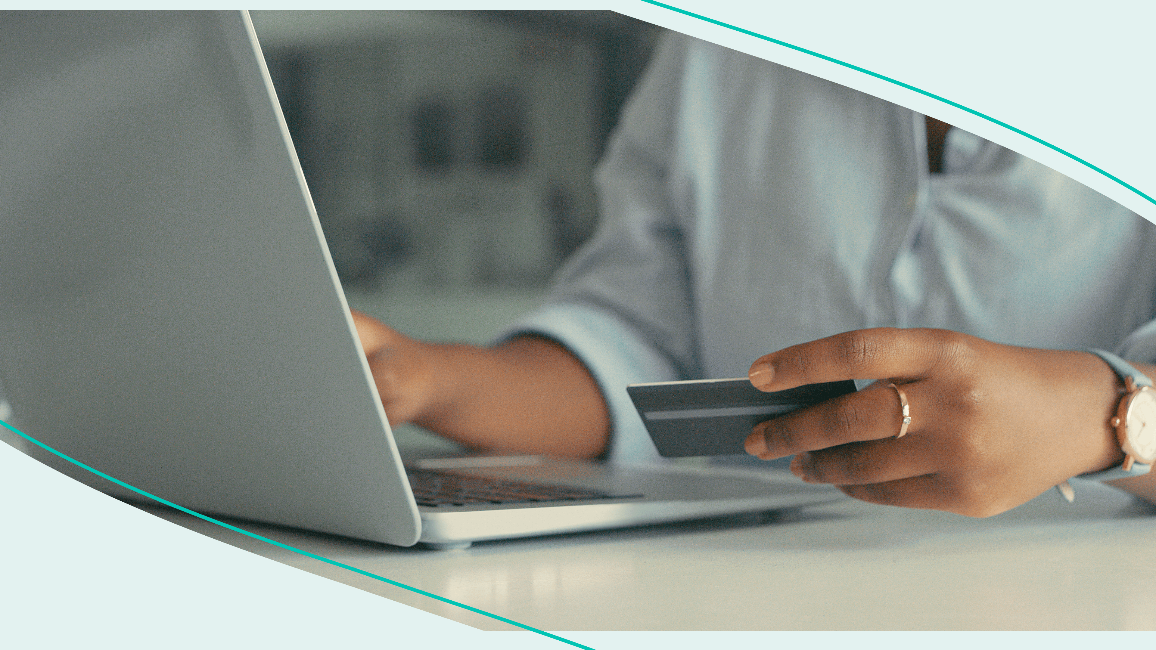 Woman holds credit card and uses laptop