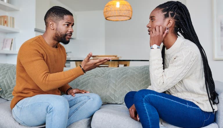 Photo of a young couple having an argument on the couch. This photo is being used to promote an article answering the question