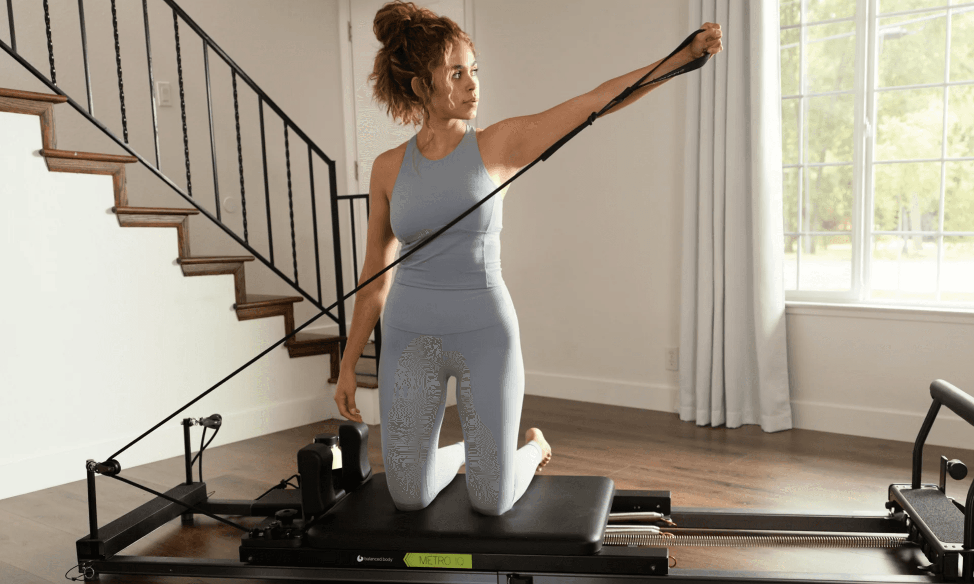 Woman using pilates reformer machine