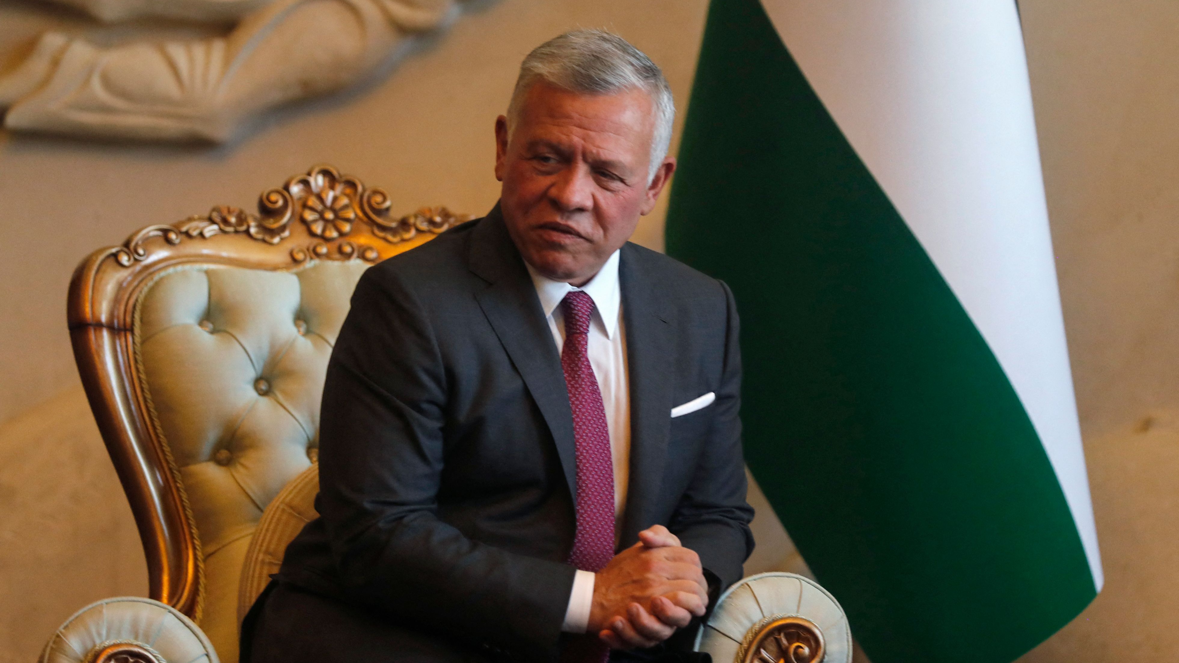 Jordanian King Abdullah II looks on as he's received by Iraq's President