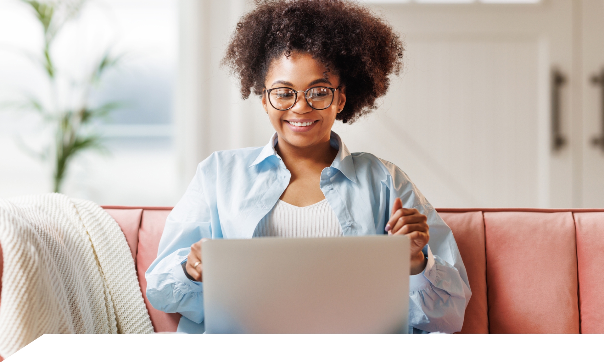 woman sitting at couch with laptop