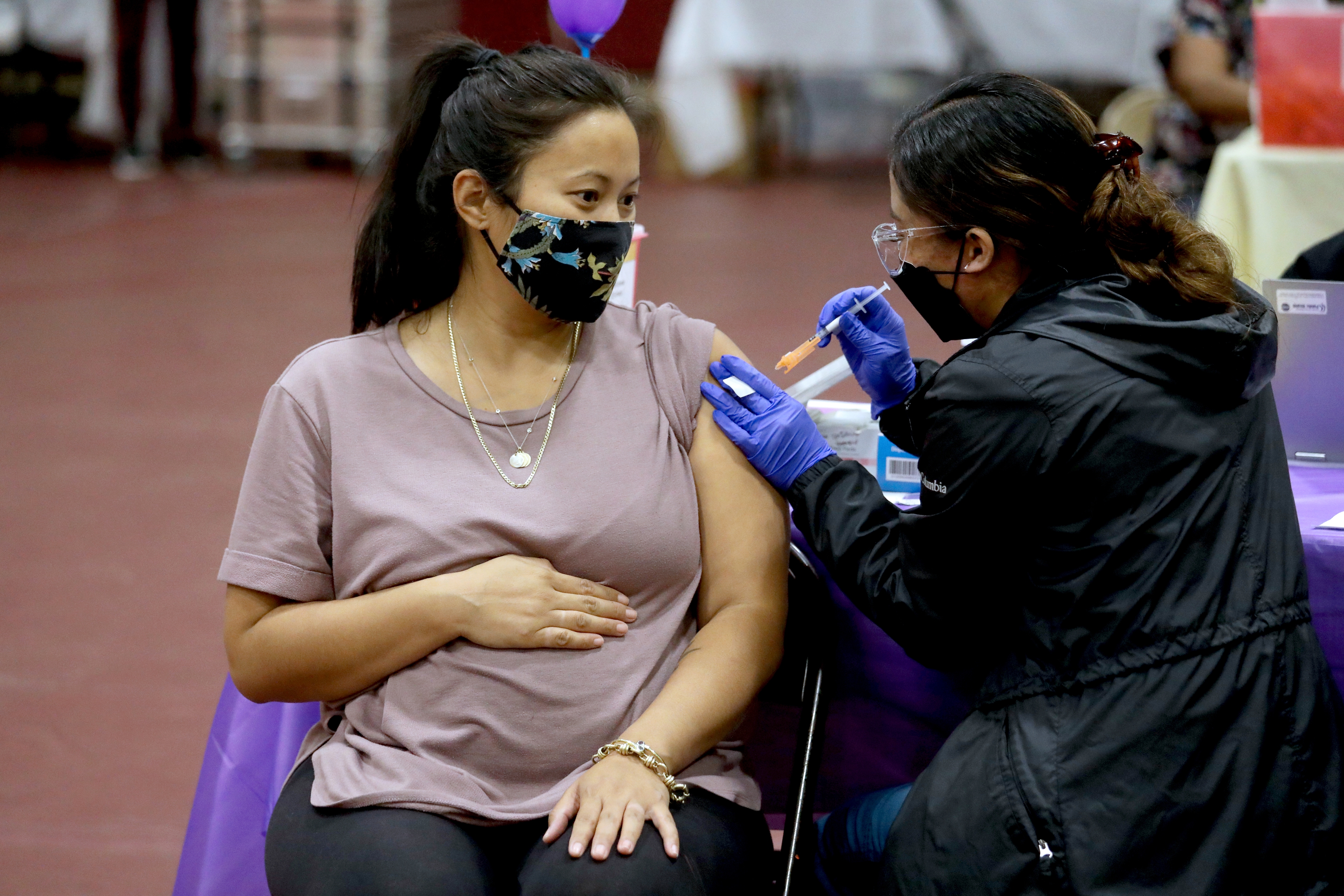 Nicole Fahey, of Altadena, six months pregnant, receives a Pfizer vaccination booster shot