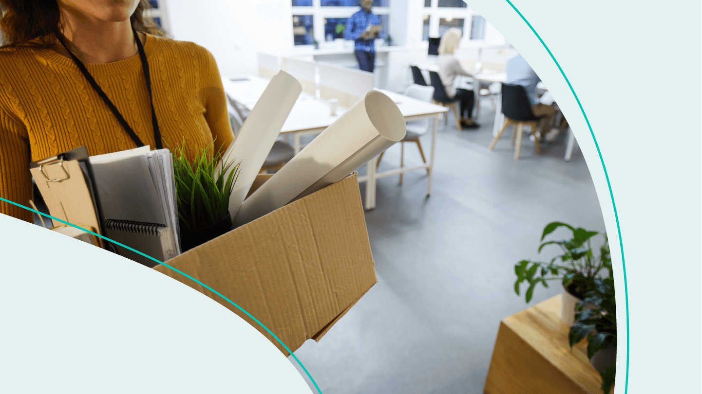 woman leaving office with box packed with desk items