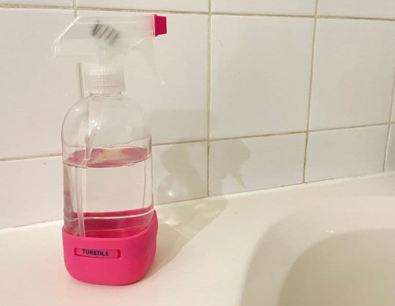 grove co. tub and tile cleaner on the edge of a bathtub