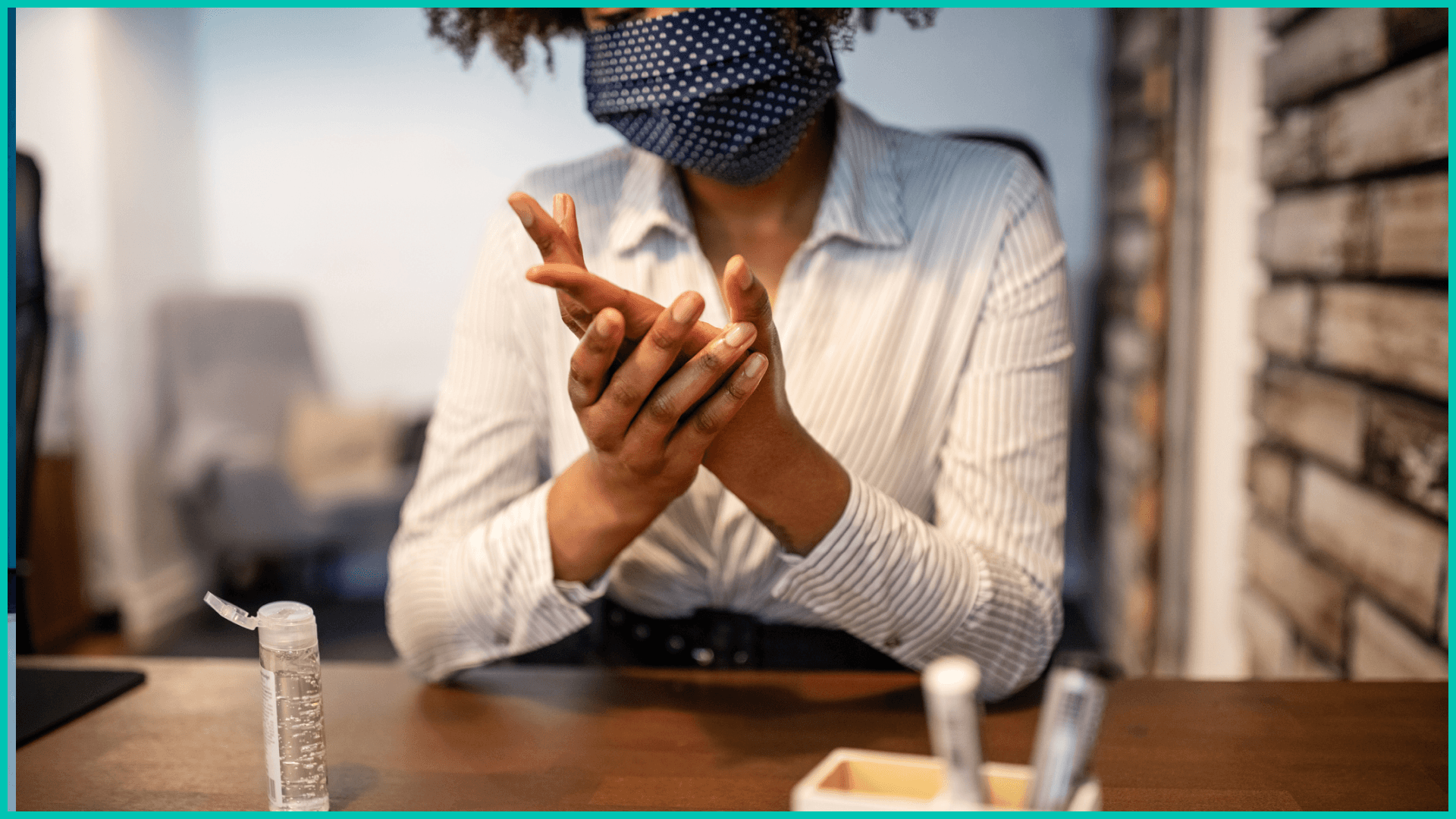 Woman sanitizing hands in office.