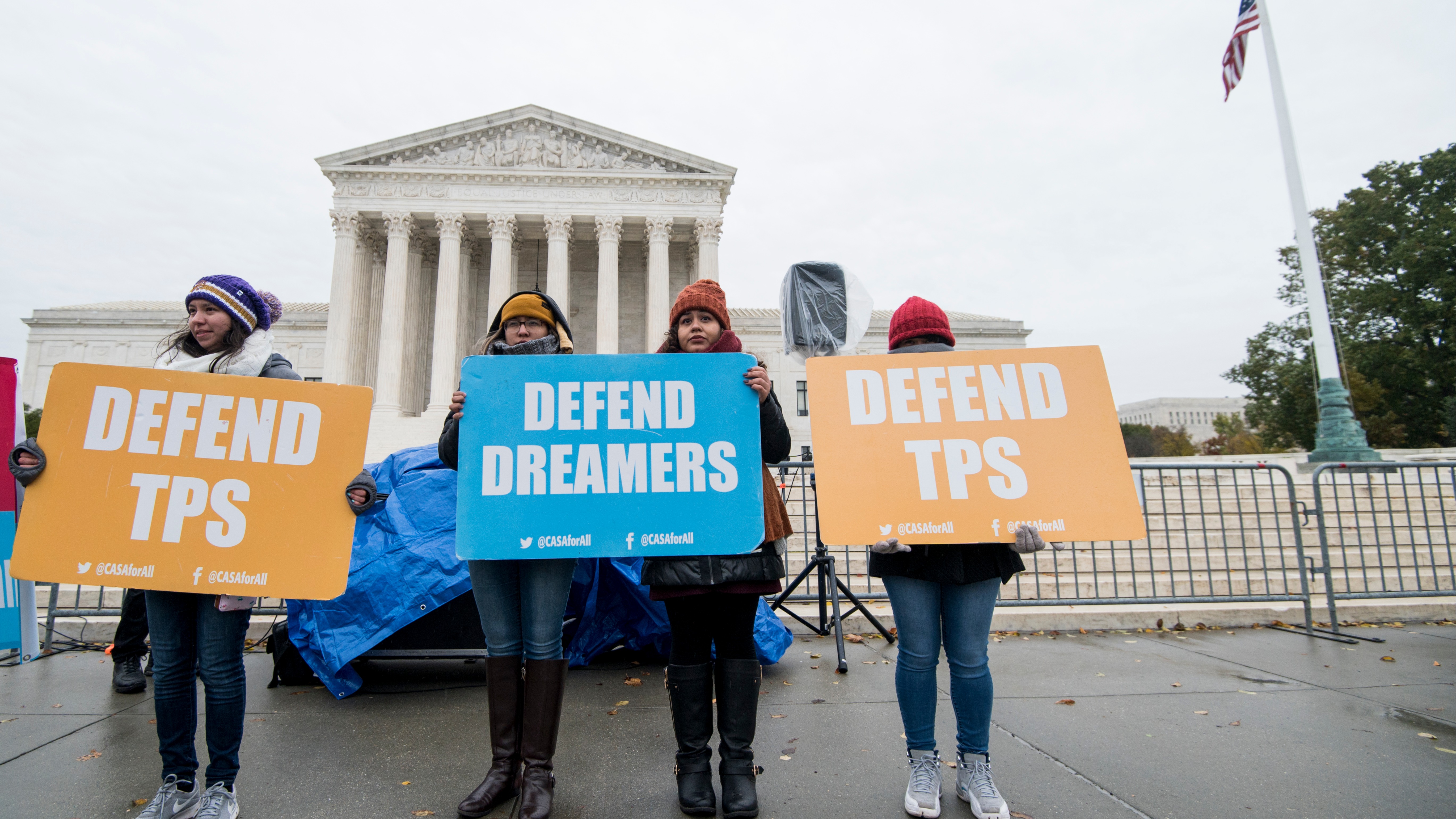 Protesters hold signs supporting dreamers and TPS outside of the U.S. Supreme Court