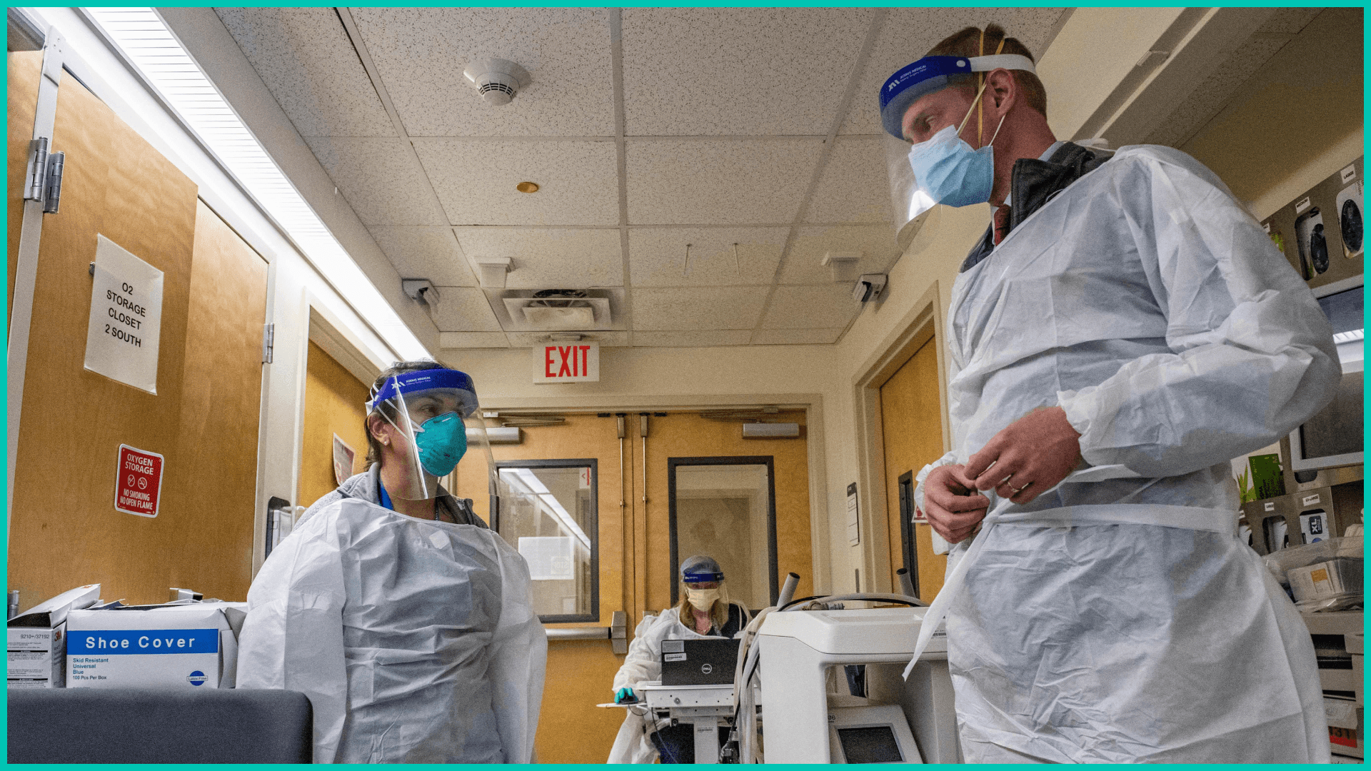 Medical workers in the Covid-19 ward in their PPE speak to each other before entering a negative pressure room