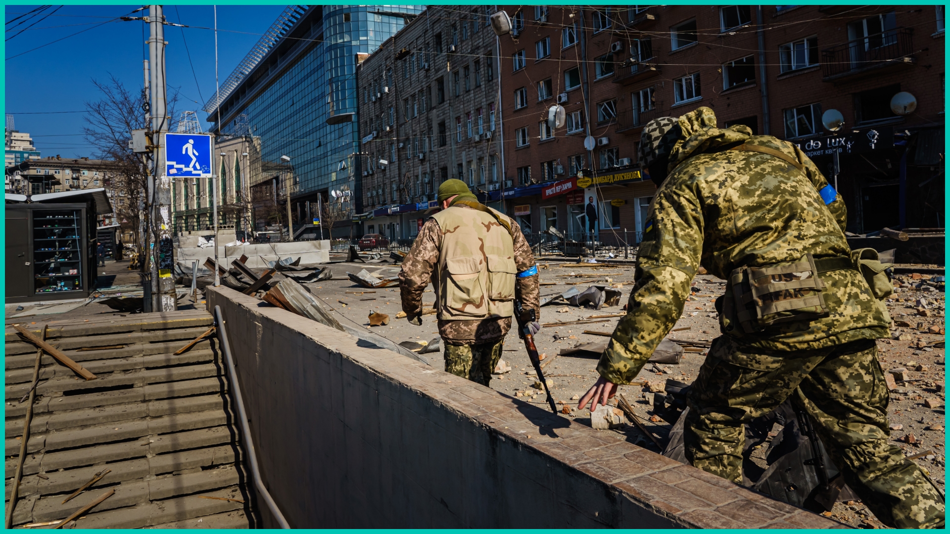 Territorial defense force soldiers inspect the damage to the Artem building caused by what authorities said is Russian bombardment
