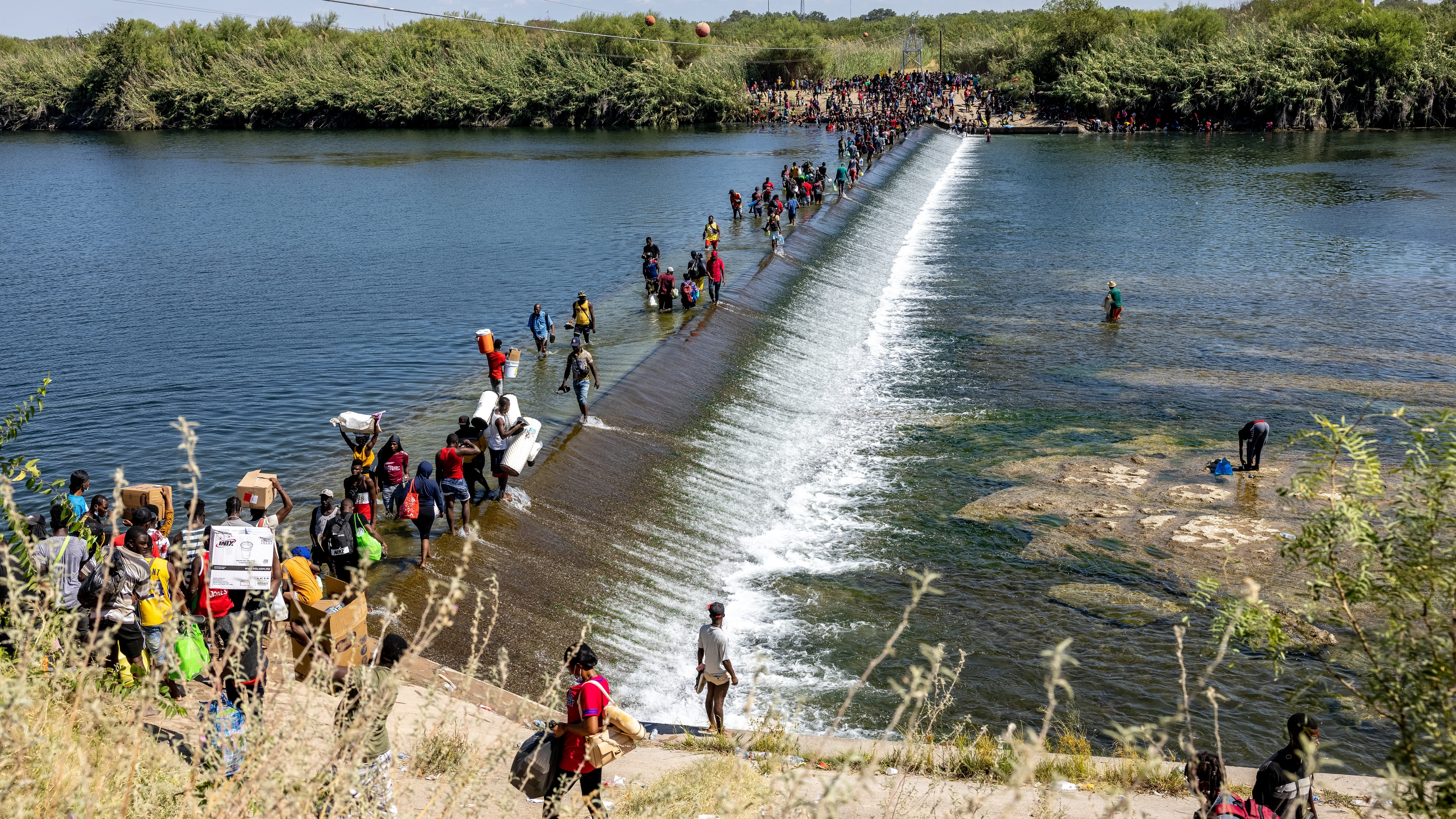 Migrants walk across the Rio Grande River in Del Rio, Texas in September 2021.