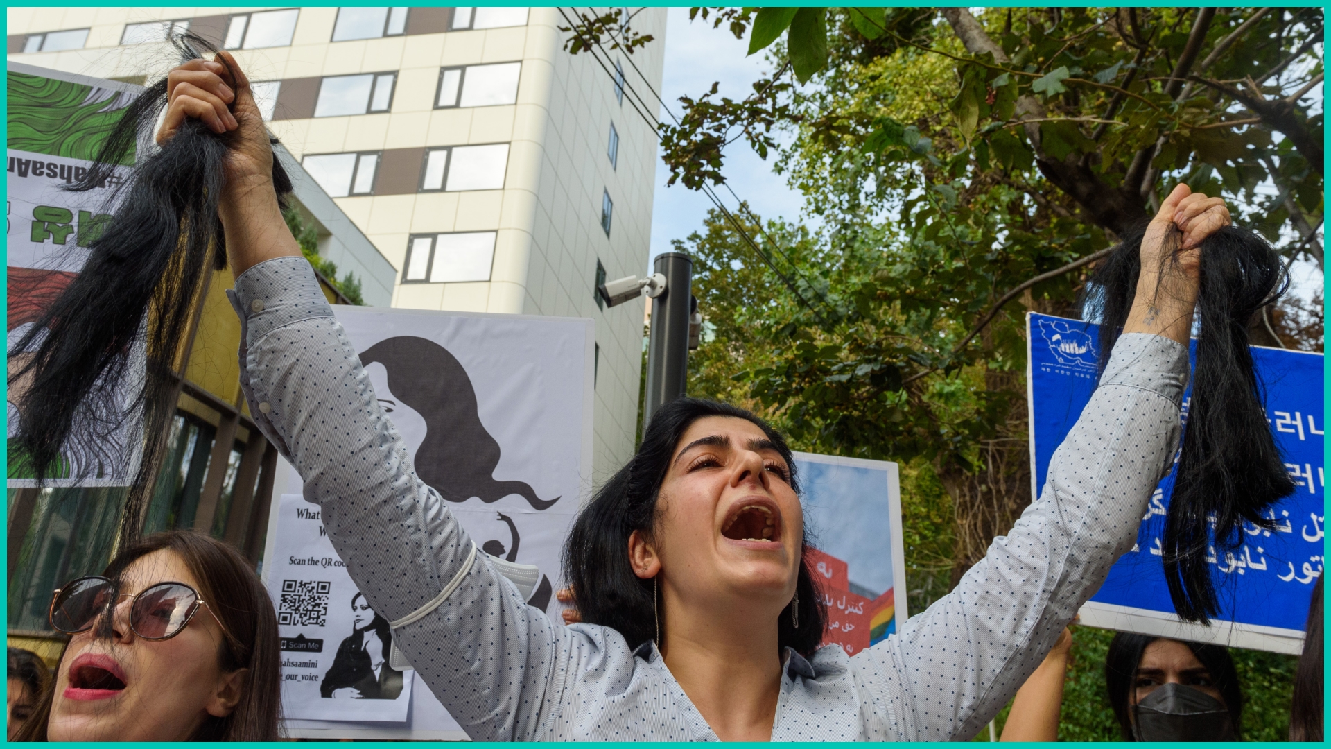 An Iranian female protester chants slogans as she holds pieces of her cut hair during a rally against the death of Iranian Mahsa Amini outside the Embassy of the Islamic Republic of Iran in Seoul.
