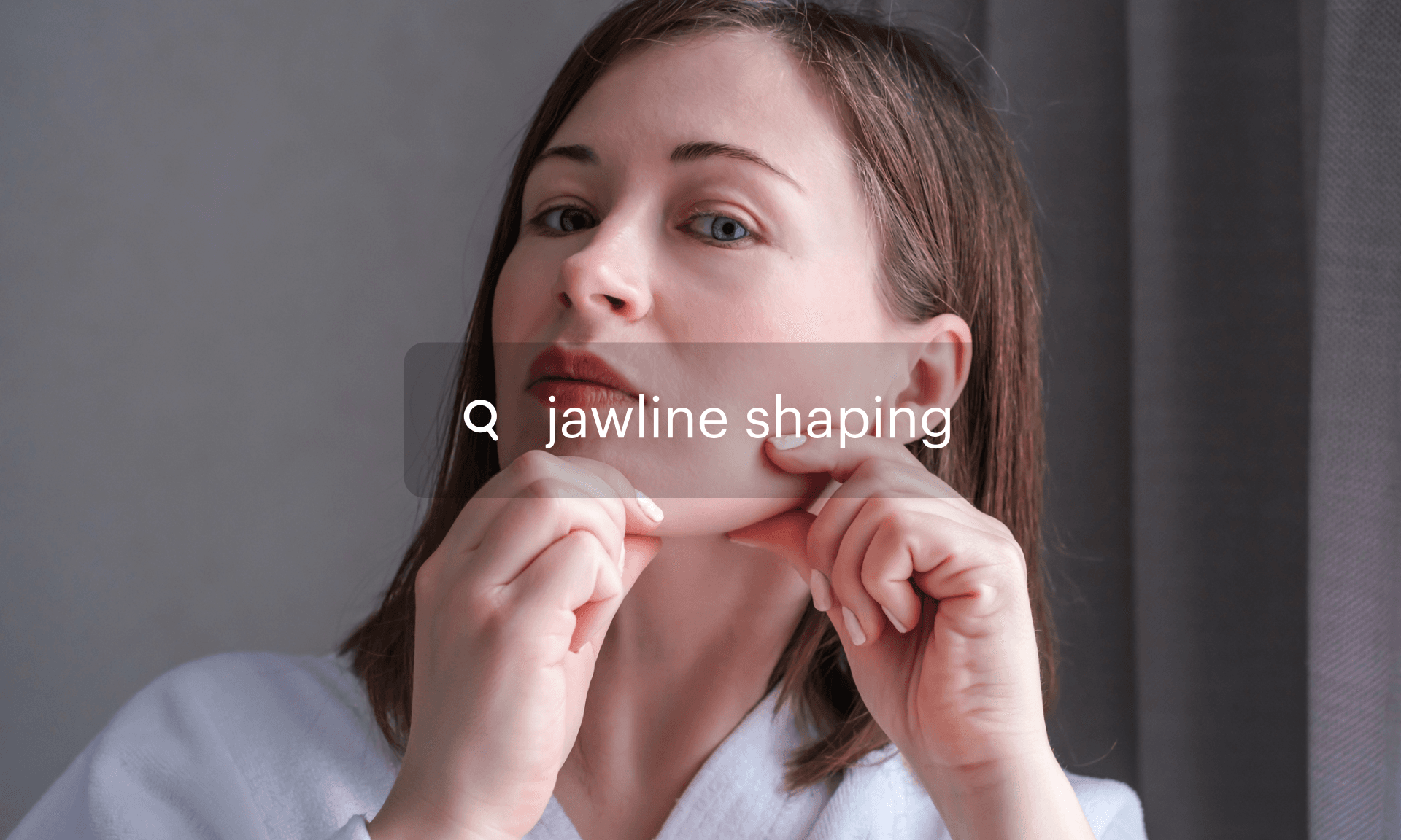 A woman looking pinching her jaw with her fingers