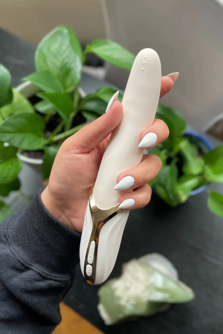 Woman with white nail polish holding cream and gold vibrator