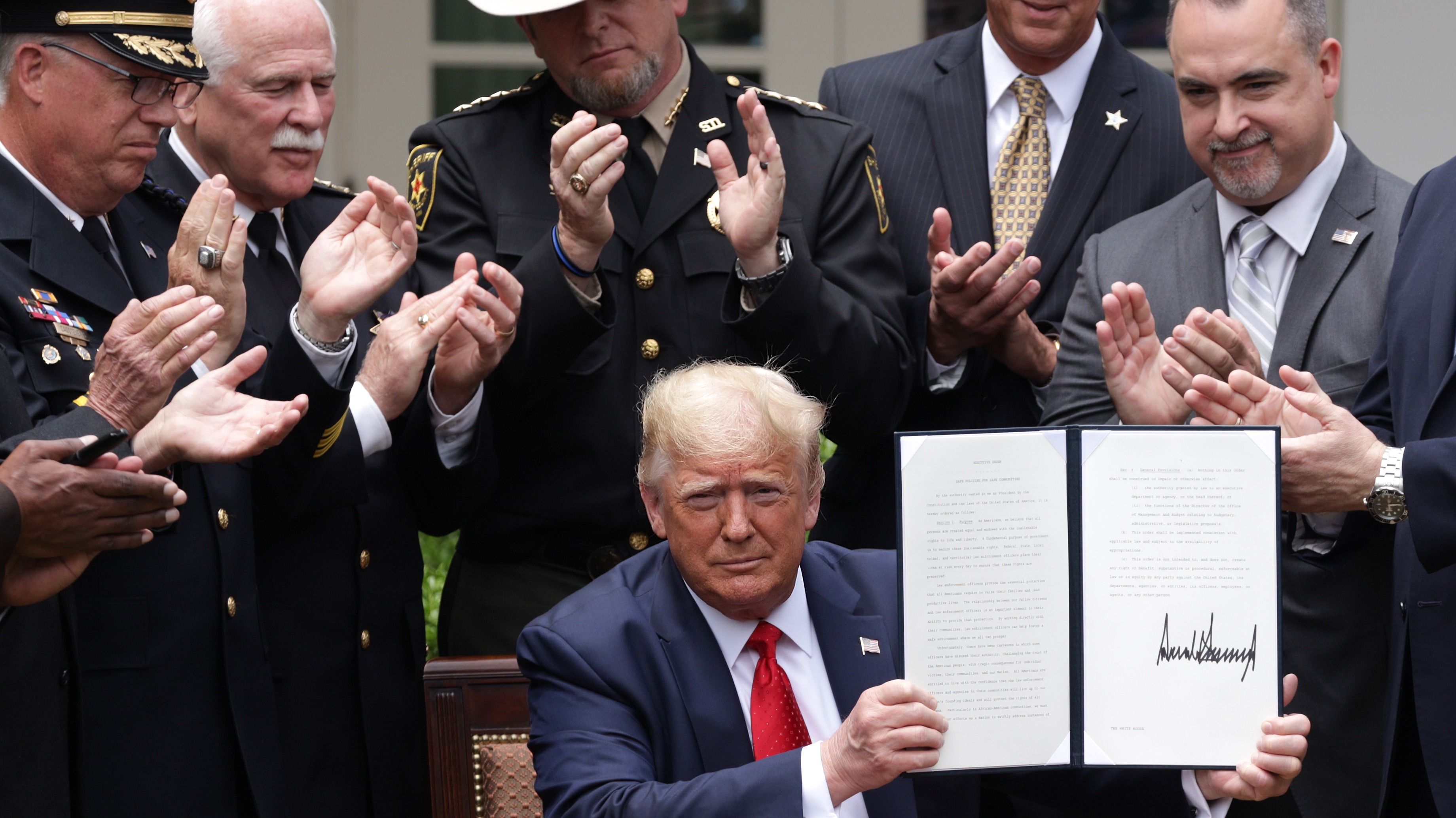 President Trump holds up an executive order he signed on “Safe Policing for Safe Communities” on June 16th, 2020.
