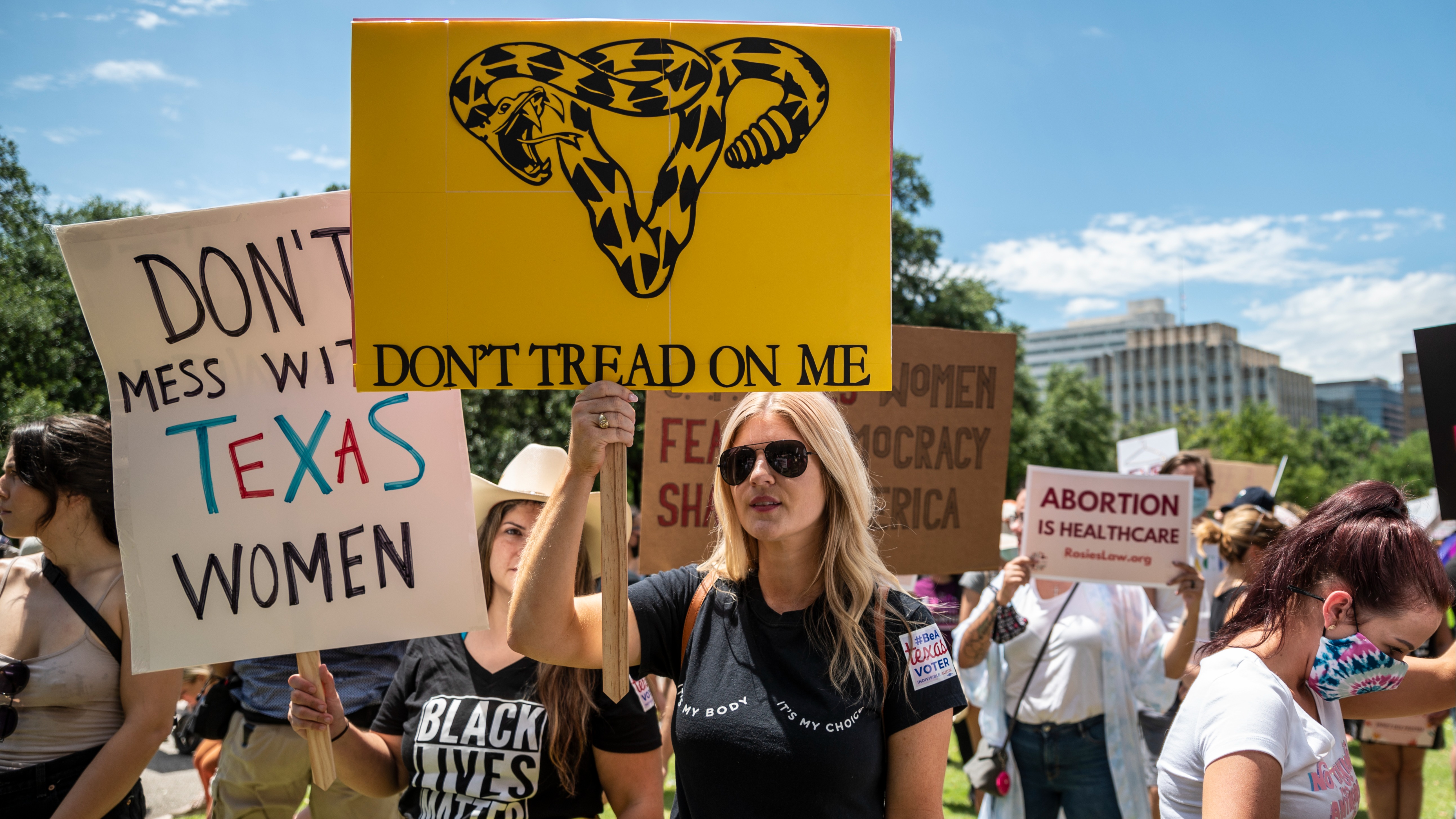 Protesters hold up signs at a protest outside the Texas state capitol