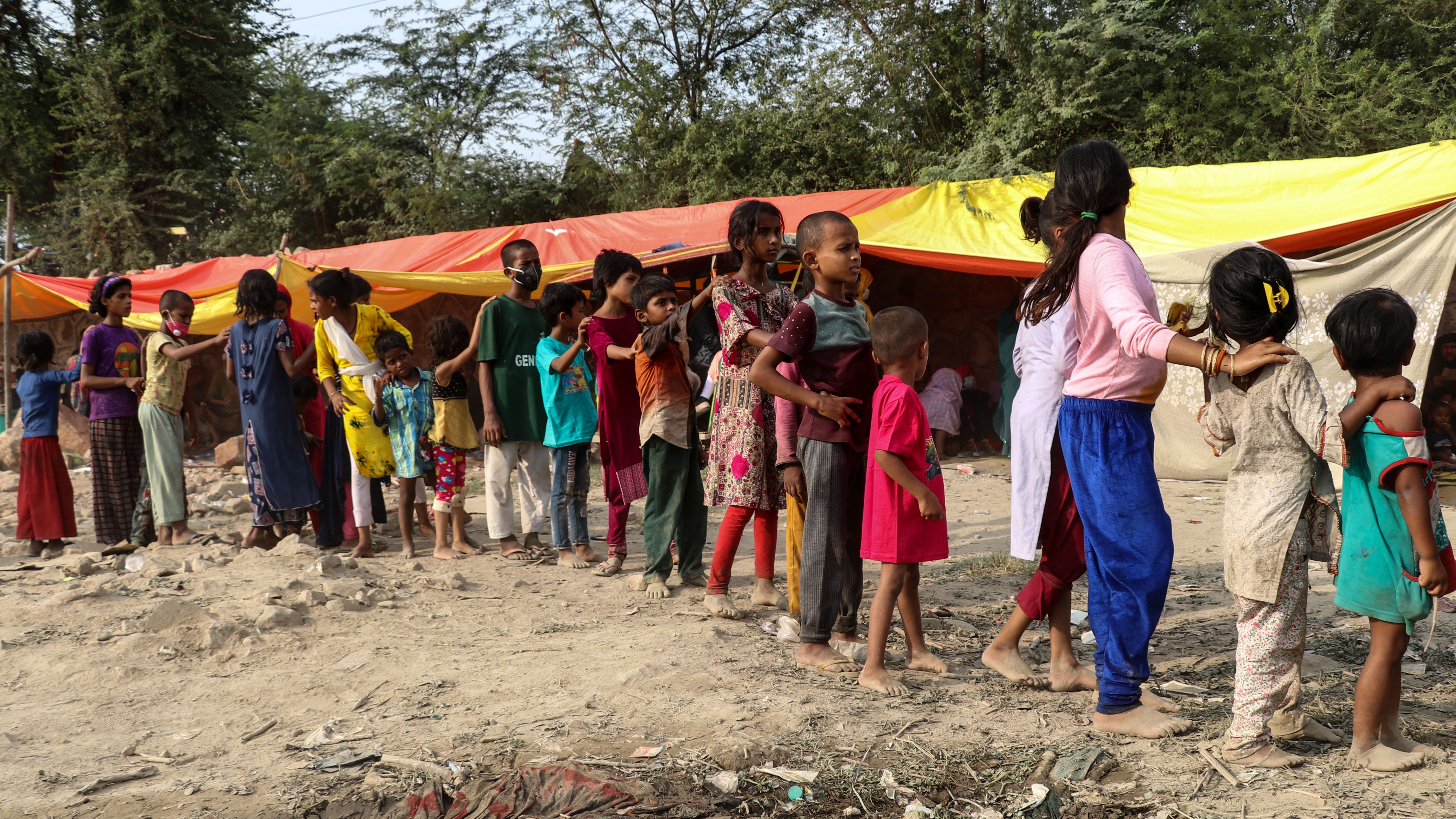 Volunteers distributes food items to Rohingya refugee childrens who wait in line at their camp, fire broke out at their camp in New Delhi, India